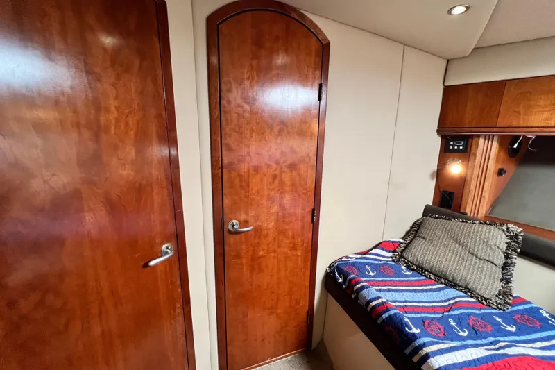 Slide: The Image of Interior of 2005 Cruisers Yachts 440 Express with wooden doors and cozy bedding. - 82