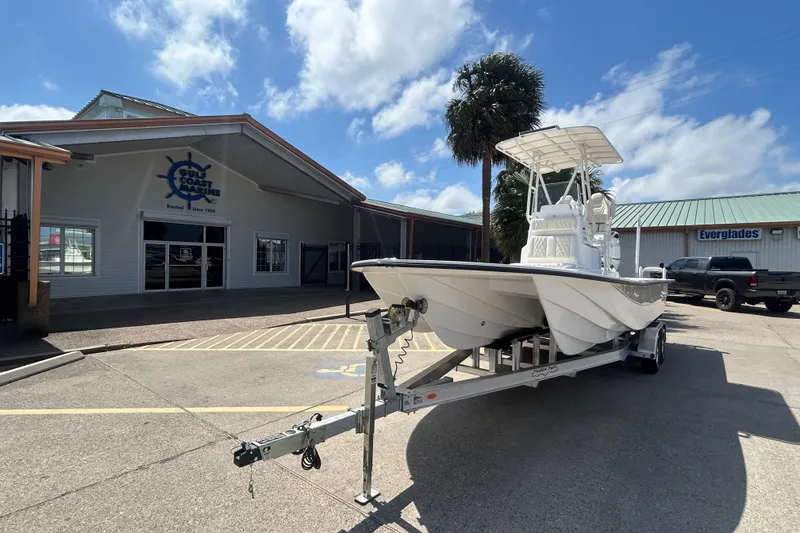 Slide: The Image of 2026 Shallow Sport 25 X3 boat on trailer outside Gulf Coast Marine building. - 23