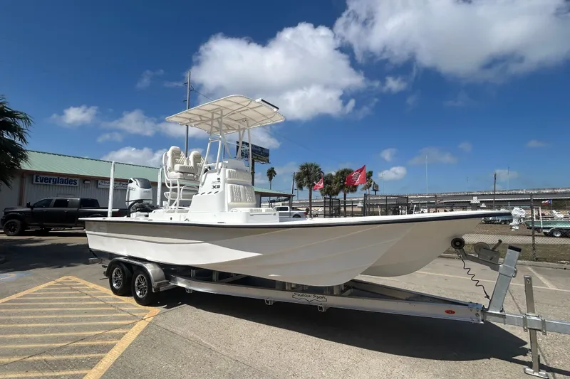 Slide: The Image of 2026 Shallow Sport 25 X3 boat on trailer under clear blue sky. - 24