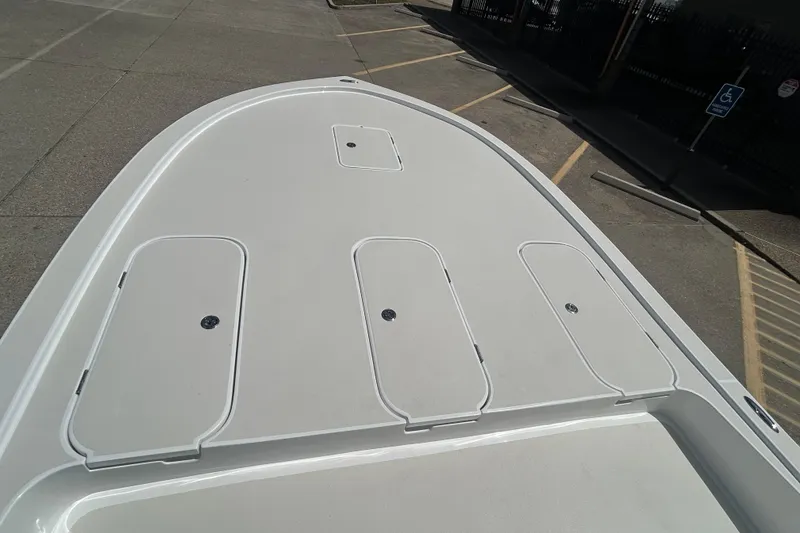 Slide: The Image of 2026 Shallow Sport 25 X3 boat deck with storage compartments in a parking area. - 26