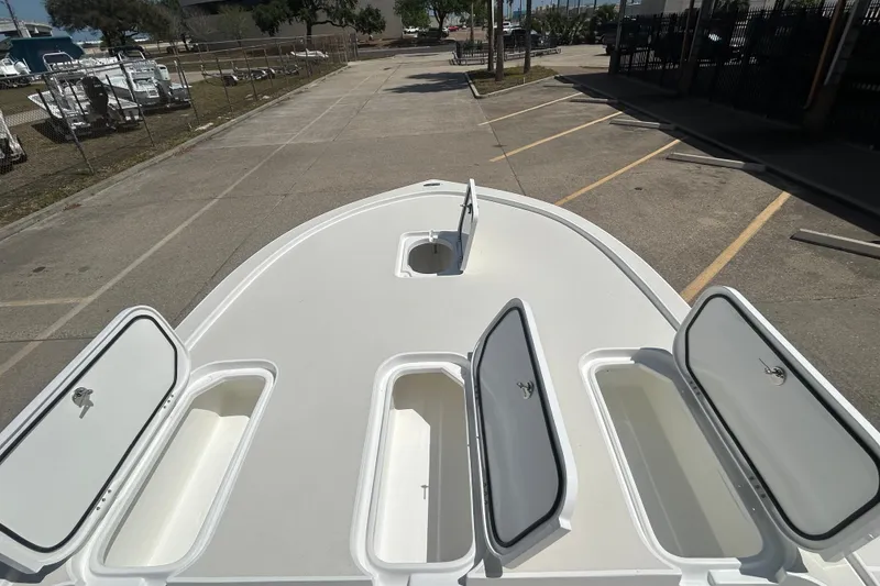 Slide: The Image of 2026 Shallow Sport 25 X3 boat deck with open storage compartments. - 27