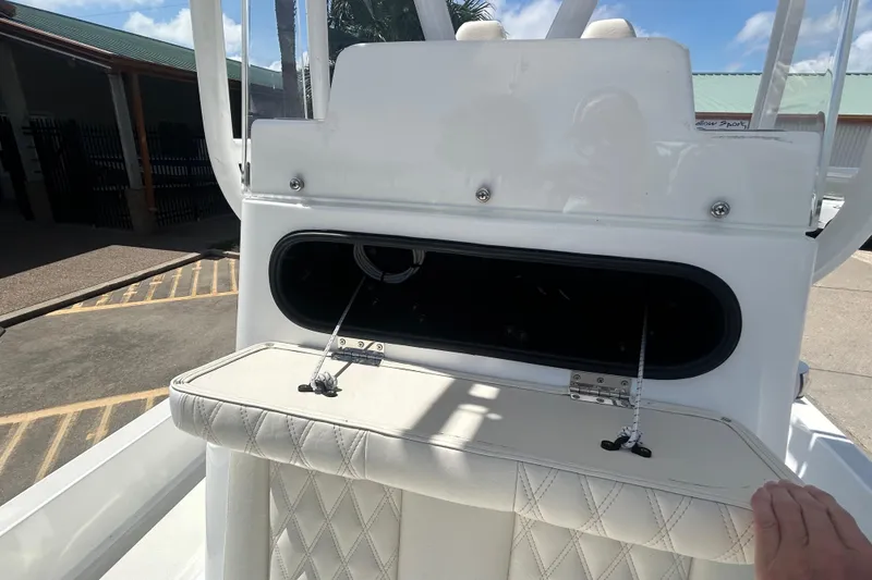 Slide: The Image of 2026 Shallow Sport 25 X3 boat with open storage compartment and cushioned seating. - 29