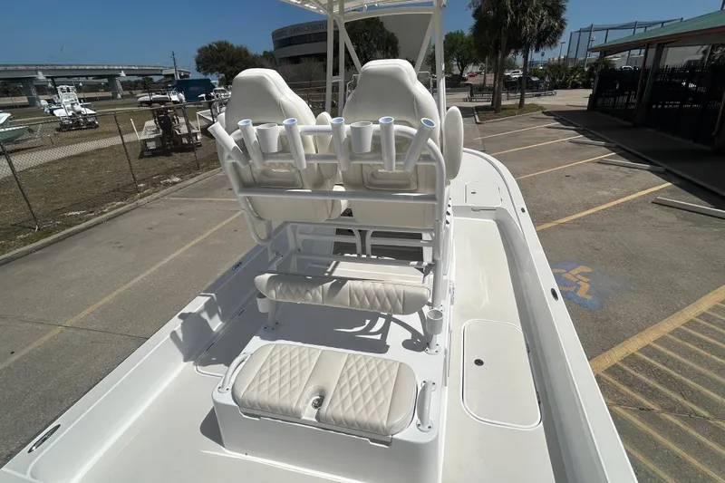 Slide: The Image of 2026 Shallow Sport 25 X3 boat with dual seating and rod holders in a parking area. - 36