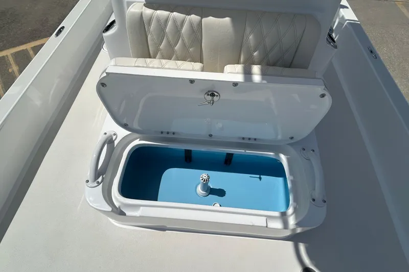 Slide: The Image of 2026 Shallow Sport 25 X3 boat with open storage compartment and cushioned seating. - 37