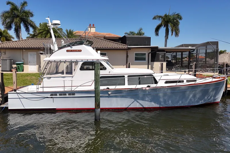 Slide: The Image of 2006 Huckins Atlantic 44 yacht docked by a waterfront home with palm trees. - 10