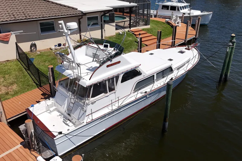 Slide: The Image of 2006 Huckins Atlantic 44 yacht docked by a waterfront home. - 11