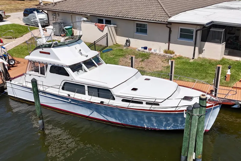 Slide: The Image of Huckins Atlantic 44 yacht, 2006 model, docked by a waterfront home. - 14