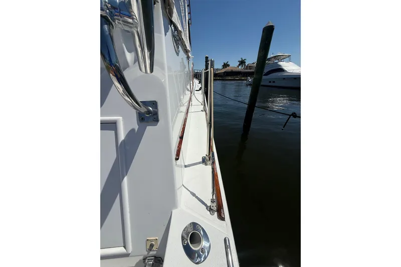 Slide: The Image of Side view of a 2006 Huckins Atlantic 44 yacht docked by the water. - 18