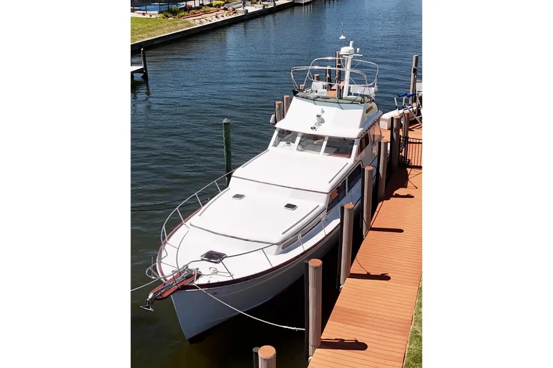 Slide: The Image of Huckins Atlantic 44 yacht, 2006 model, docked in a serene marina setting. - 2