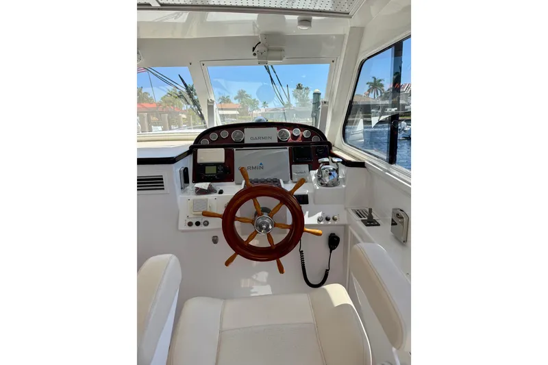 Slide: The Image of Helm of 2006 Huckins Atlantic 44 yacht with wooden steering wheel and navigation equipment. - 24