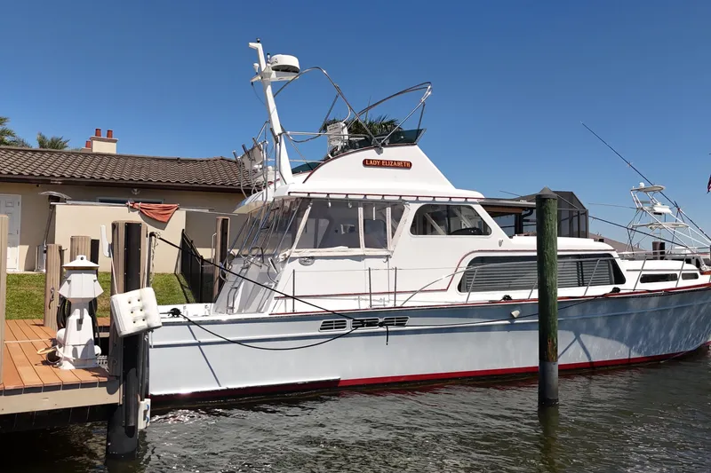 Slide: The Image of 2006 Huckins Atlantic 44 yacht docked by a waterfront home. - 4