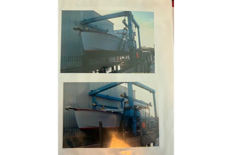 Slide: The Image of 2006 Huckins Atlantic 44 yacht in dry dock, supported by a blue boat lift. - 40