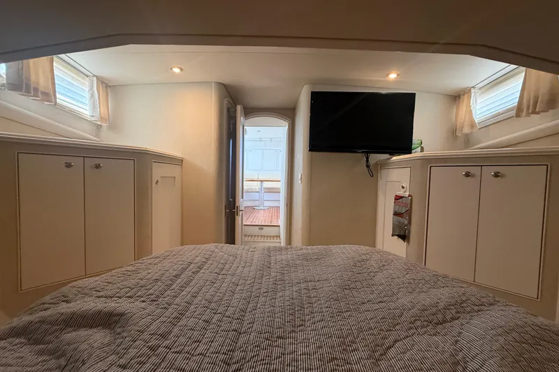 Slide: The Image of Interior cabin of 2006 Huckins Atlantic 44 yacht with bed, cabinets, and TV. - 78