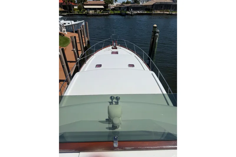 Slide: The Image of 2006 Huckins Atlantic 44 yacht docked by waterfront homes. - 79