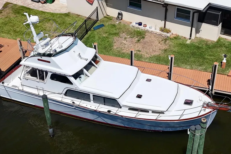 Slide: The Image of 2006 Huckins Atlantic 44 yacht docked by a waterfront home. - 8