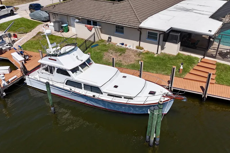 Slide: The Image of Huckins Atlantic 44 yacht, 2006 model, docked beside a waterfront home. - 9