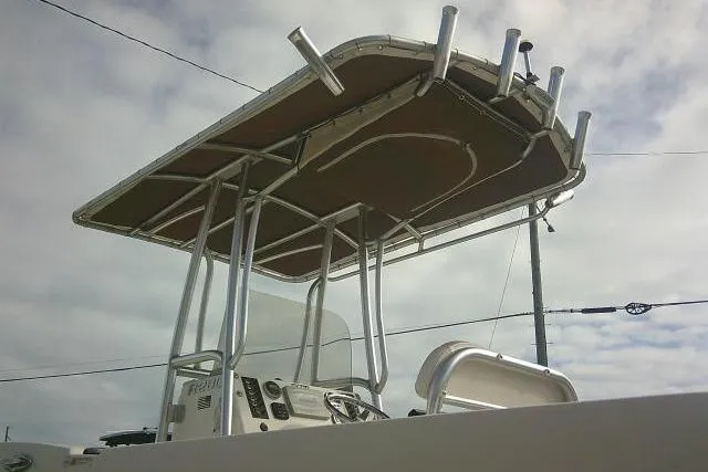 Slide: The Image of 2016 Robalo R200 Center Console boat with T-top and rod holders under cloudy sky. - 14