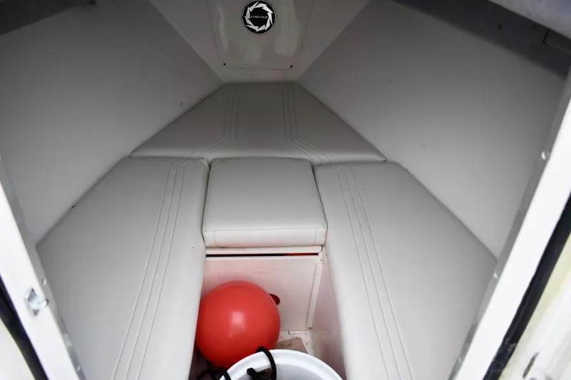 Slide: The Image of 2001 Fountain 31 Tournament Edition boat cabin interior with white seating and red buoy. - 13