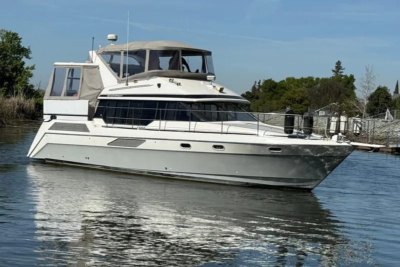 The Image of 1991 Bayliner 4387 Motoryacht cruising on calm water under clear skies. - 0