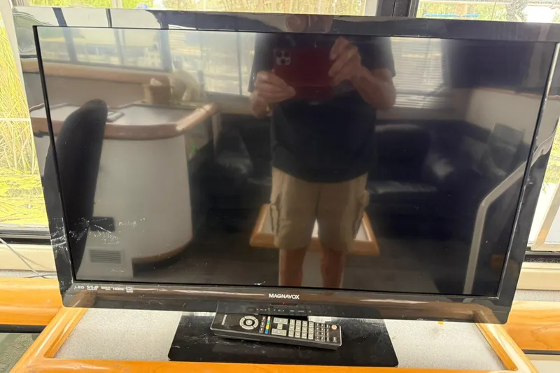 Slide: The Image of Flat-screen TV with remote on a 1991 Bayliner 4387 Motoryacht interior. - 15