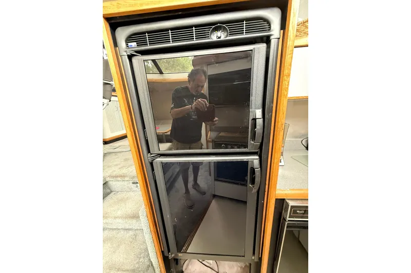 Slide: The Image of Refrigerator inside 1991 Bayliner 4387 Motoryacht, reflecting interior details. - 19