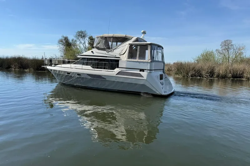 Slide: The Image of 1991 Bayliner 4387 Motoryacht cruising on calm water under clear blue sky. - 3