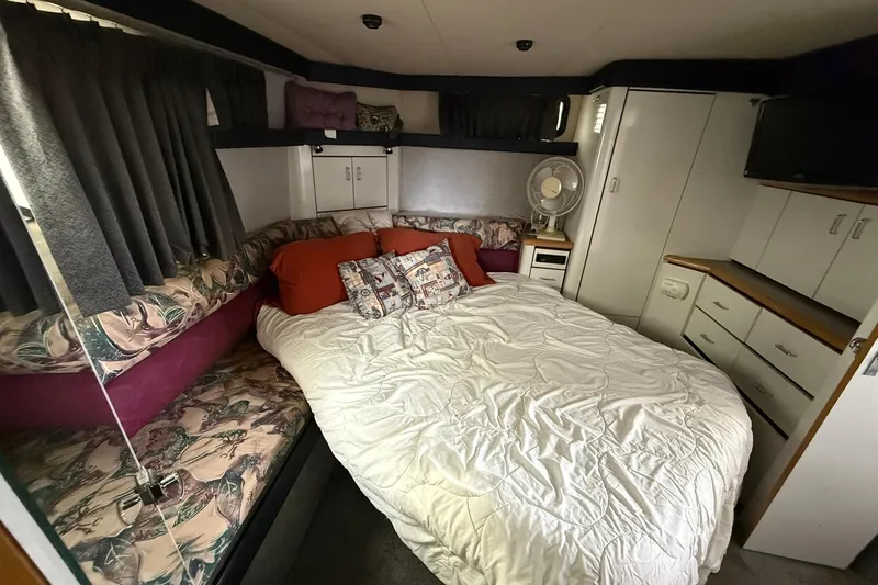 Slide: The Image of Cozy bedroom interior of 1991 Bayliner 4387 Motoryacht with bed, fan, and storage cabinets. - 34