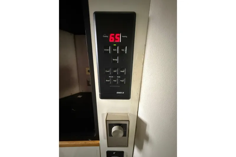 Slide: The Image of Thermostat and A/C control panels on 1991 Bayliner 4387 Motoryacht, displaying temperature settings. - 46