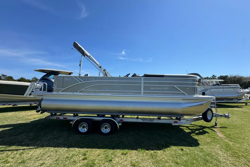The Image of 2026 Bennington 22 S Fish pontoon boat on trailer under clear blue sky. - 1