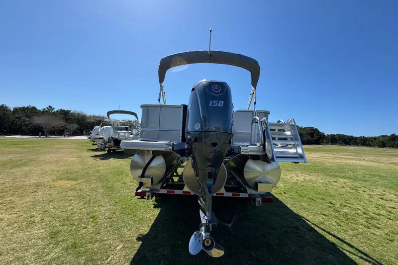 Slide: The Image of 2026 Bennington 22 S Fish pontoon boat with Yamaha 150 engine on grassy field. - 12