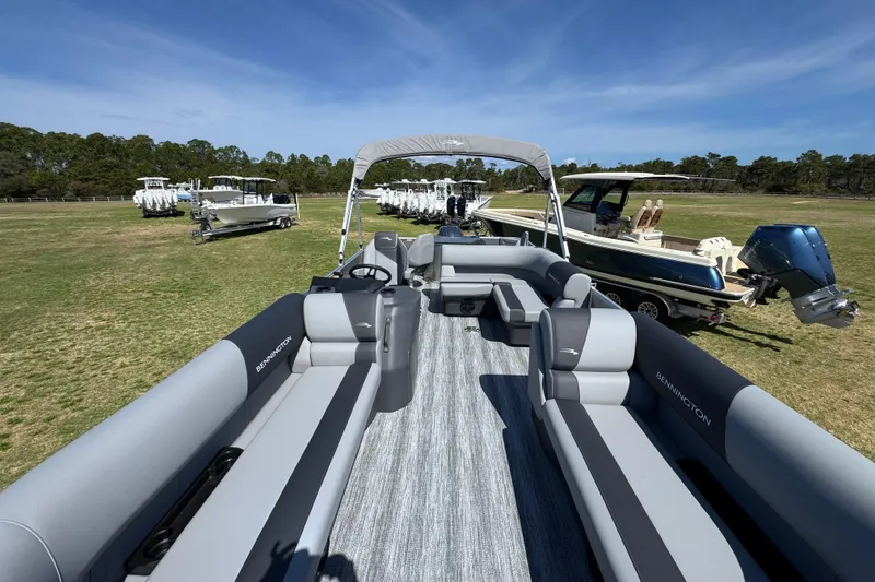 Slide: The Image of 2026 Bennington 22 S Fish pontoon boat on grassy field, surrounded by other boats. - 14