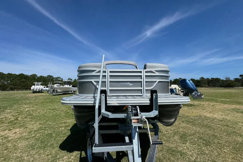 Slide: The Image of 2026 Bennington 22 S Fish pontoon boat on trailer under clear blue sky. - 3