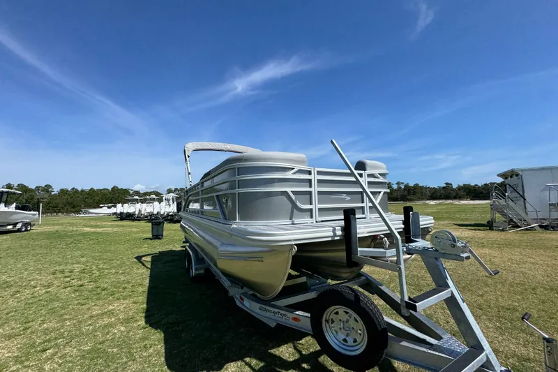 Slide: The Image of 2026 Bennington 22 S Fish pontoon boat on trailer under clear blue sky. - 4