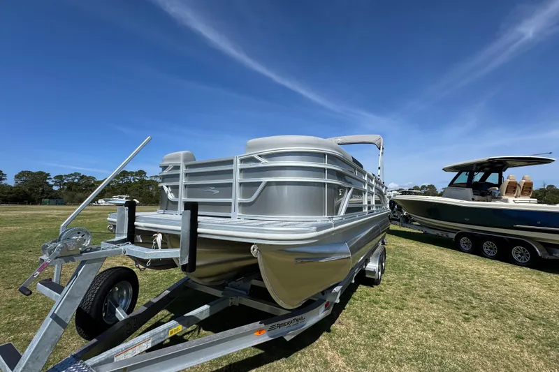 Slide: The Image of 2026 Bennington 22 S Fish pontoon boat on trailer under clear blue sky. - 5