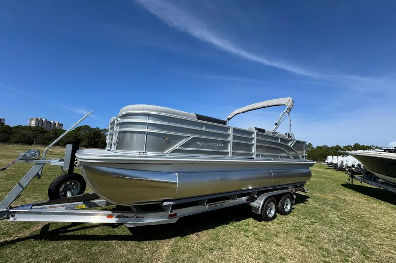 Slide: The Image of 2026 Bennington 22 S Fish pontoon boat on trailer under clear blue sky. - 6