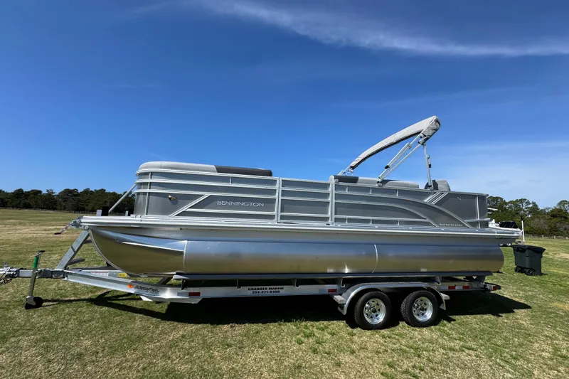 Slide: The Image of 2026 Bennington 22 S Fish pontoon boat on trailer under clear blue sky. - 7