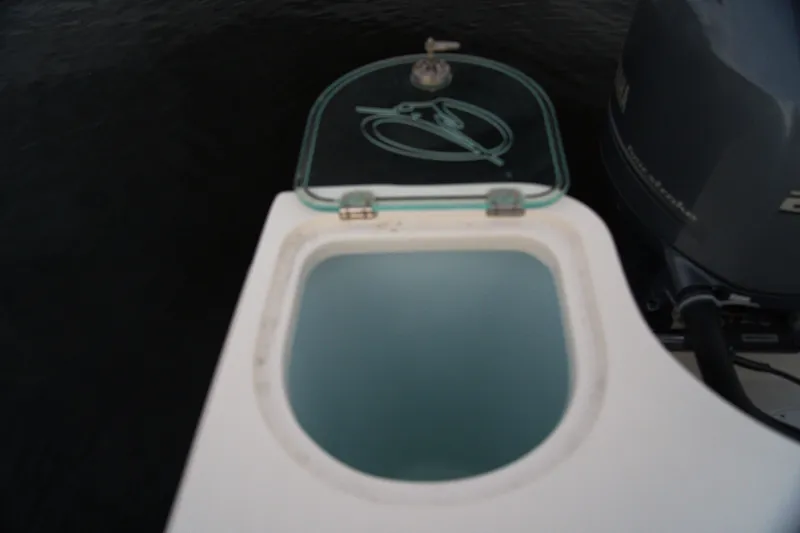 Slide: The Image of Livewell on 2020 Sailfish 270 WAC boat with open lid, near outboard motor. - 20