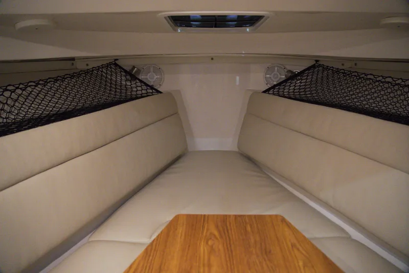 Slide: The Image of Interior cabin of 2020 Sailfish 270 WAC boat with beige seating and storage nets. - 27