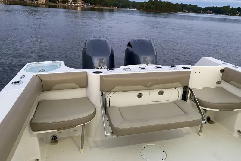 Slide: The Image of 2020 Sailfish 270 WAC boat interior with seating and dual engines on a calm lake. - 9