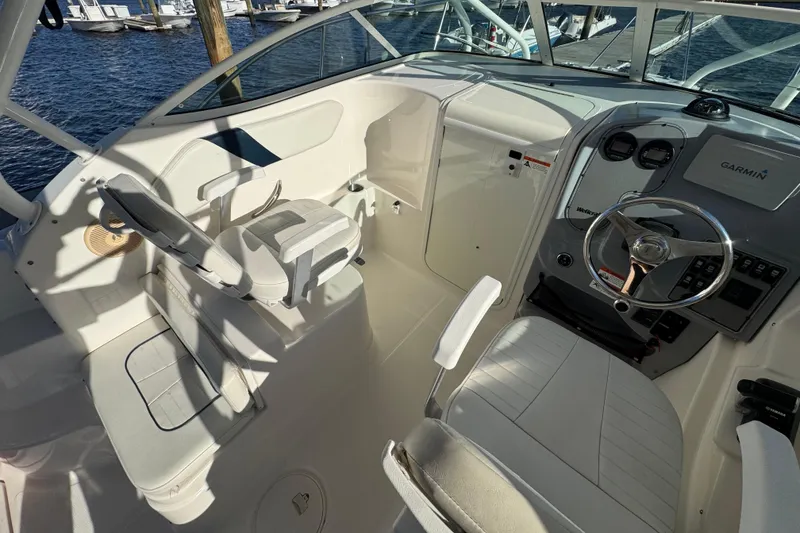 Slide: The Image of Interior view of 2014 Wellcraft 252 Coastal boat cockpit with steering wheel and seating. - 14