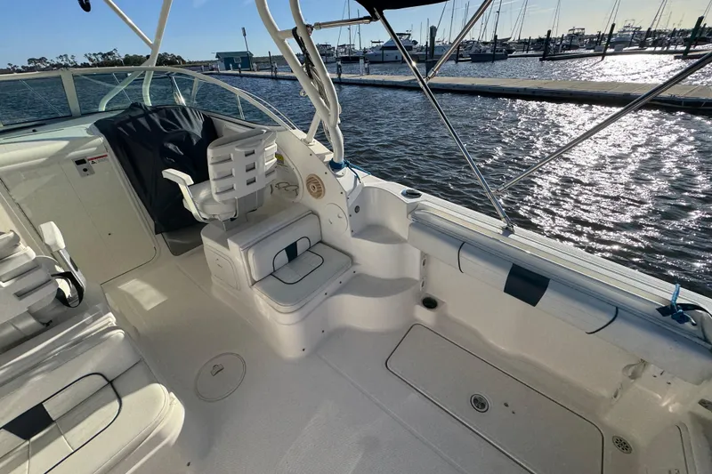 Slide: The Image of 2014 Wellcraft 252 Coastal boat interior with seating, docked by a marina. - 24