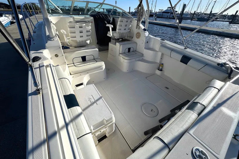Slide: The Image of 2014 Wellcraft 252 Coastal boat interior with seating and fishing amenities at a marina. - 25