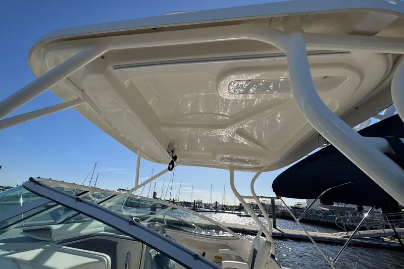 Slide: The Image of 2014 Wellcraft 252 Coastal boat with a sturdy T-top, docked at a marina. - 9