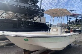 The Image of 2016 Sundance B22CCR boat with canopy, docked under a partly cloudy sky. - 0