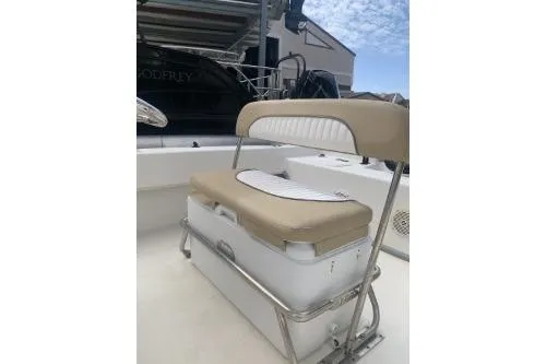 Slide: The Image of 2016 Sundance B22CCR boat seat with beige cushion and storage compartment. - 5