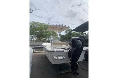 Slide: The Image of 2016 Sundance B22CCR boat with outboard motor, parked outdoors under cloudy sky. - 6