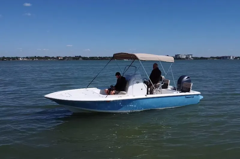Slide: The Image of 2020 Tidewater 2110 Bay Max boat cruising on calm waters under a clear blue sky. - 17