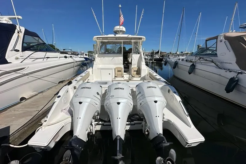 Slide: The Image of 2020 Pursuit OS 355 Offshore boat with triple Yamaha 300 engines docked at marina. - 2