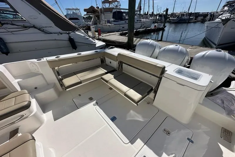 Slide: The Image of 2020 Pursuit OS 355 Offshore boat interior with seating, docked at marina. - 38