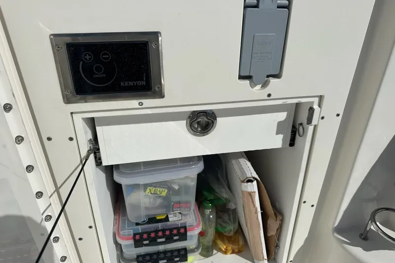 Slide: The Image of Storage compartment on a 2020 Pursuit OS 355 Offshore boat with fishing gear and controls. - 40
